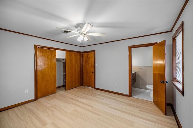 unfurnished bedroom featuring ensuite bath, ceiling fan, crown molding, light hardwood / wood-style flooring, and a closet