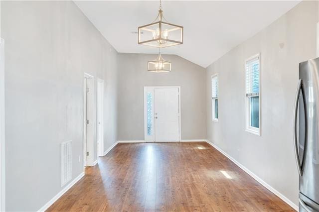 foyer with hardwood / wood-style flooring and vaulted ceiling