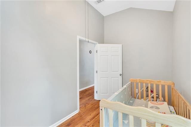 bedroom featuring hardwood / wood-style floors and vaulted ceiling