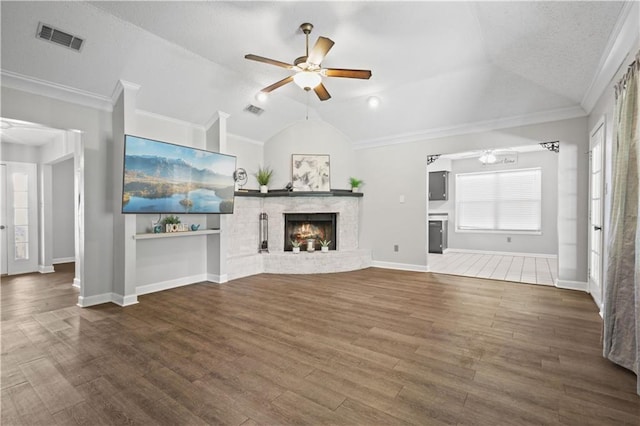 unfurnished living room featuring lofted ceiling, ceiling fan, wood-type flooring, a fireplace, and a textured ceiling