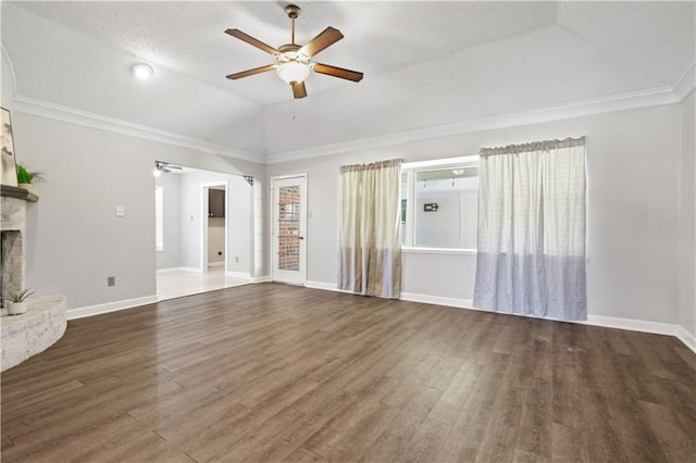 unfurnished living room with a brick fireplace, crown molding, vaulted ceiling, and dark wood-type flooring