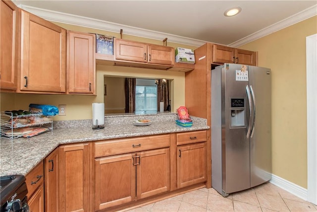 kitchen featuring light stone countertops, black stove, stainless steel fridge, light tile patterned floors, and ornamental molding