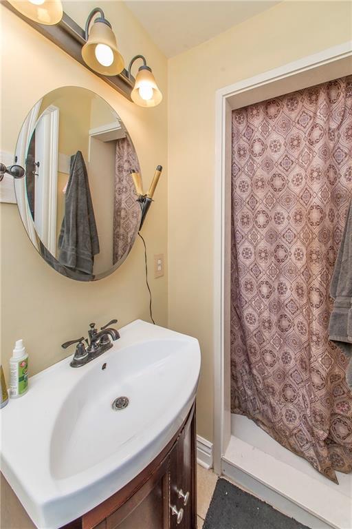 bathroom featuring tile patterned flooring, vanity, and a shower with shower curtain