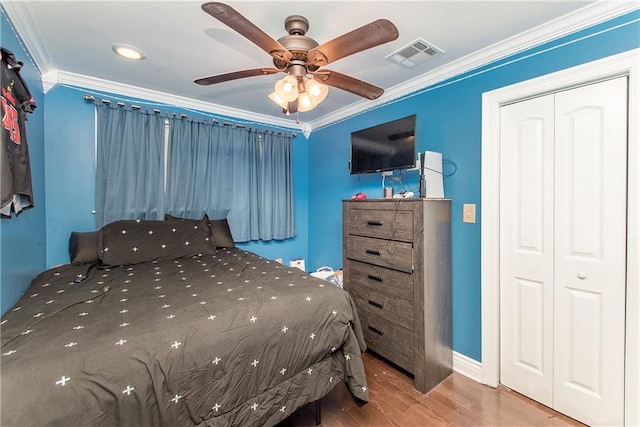 bedroom with ceiling fan, a closet, wood-type flooring, and ornamental molding