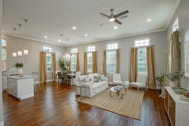 interior space featuring ceiling fan with notable chandelier, crown molding, and dark hardwood / wood-style floors