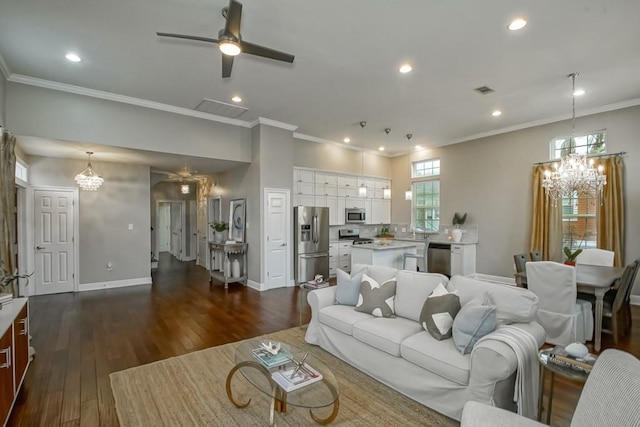 living room with ceiling fan with notable chandelier, a healthy amount of sunlight, dark wood-type flooring, and crown molding