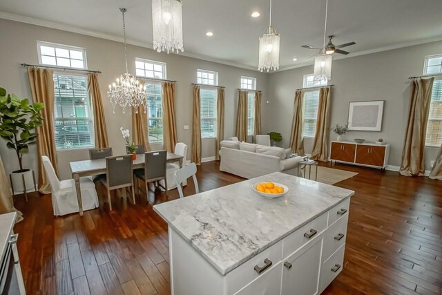 kitchen featuring white cabinetry, a center island, ornamental molding, dark hardwood / wood-style floors, and pendant lighting