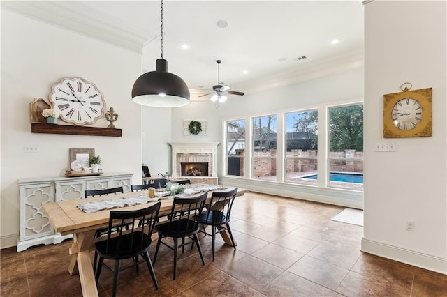 dining room featuring ceiling fan, dark tile patterned floors, and ornamental molding