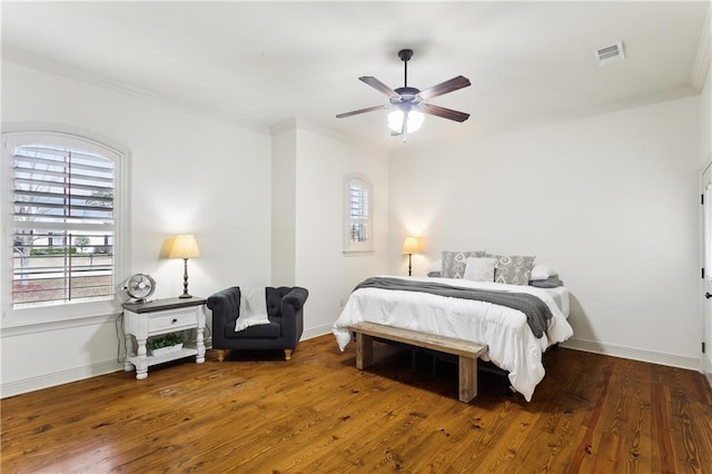 bedroom featuring ceiling fan, ornamental molding, and dark wood-type flooring