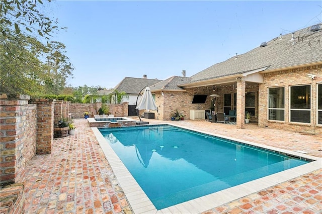 view of pool with an in ground hot tub and a patio