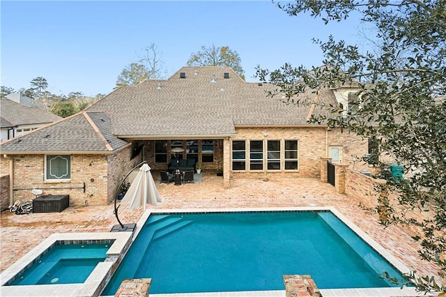 view of swimming pool featuring a patio area and an in ground hot tub