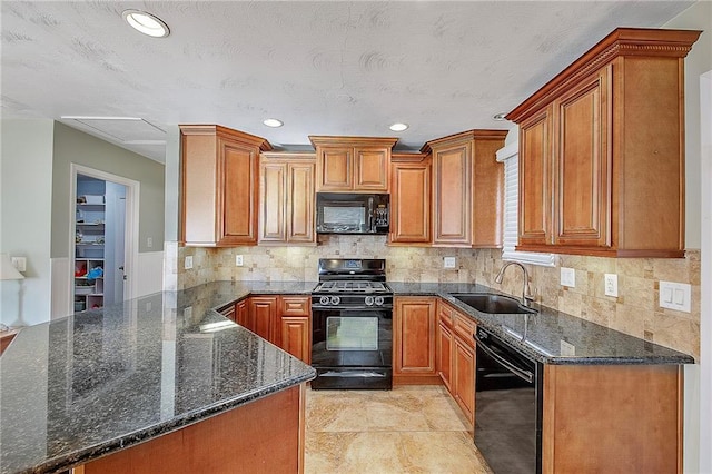 kitchen featuring black appliances, backsplash, dark stone countertops, and sink