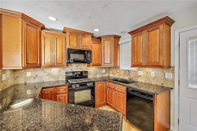 kitchen with sink, tasteful backsplash, dark stone countertops, and black appliances