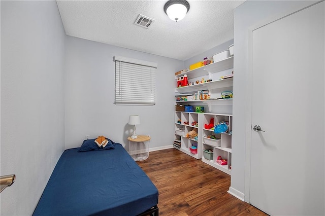 bedroom featuring a textured ceiling and dark wood-type flooring