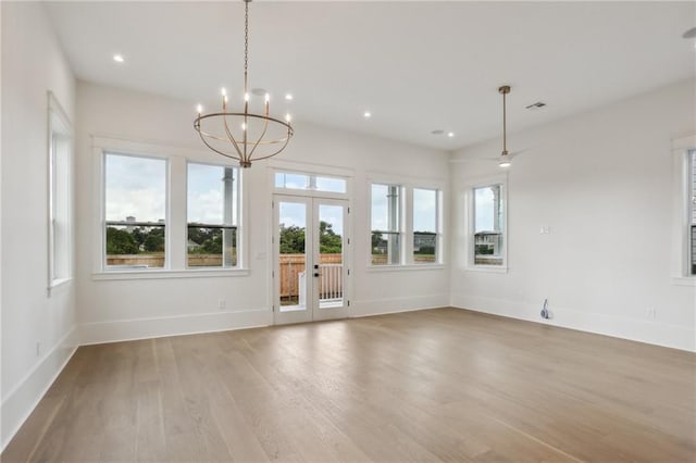 interior space with french doors, light hardwood / wood-style flooring, and an inviting chandelier