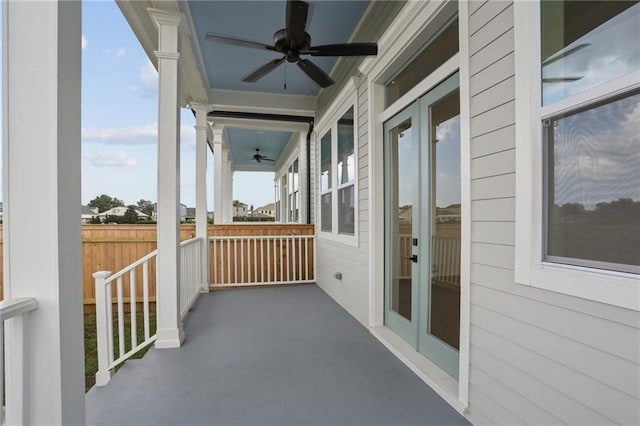 balcony with ceiling fan, a porch, and french doors