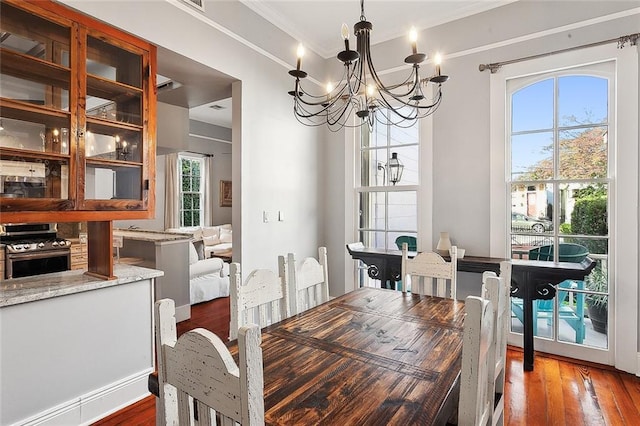 dining room featuring dark hardwood / wood-style floors, an inviting chandelier, and ornamental molding