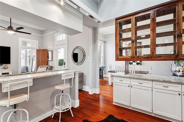 kitchen featuring ceiling fan, white cabinets, and light stone countertops