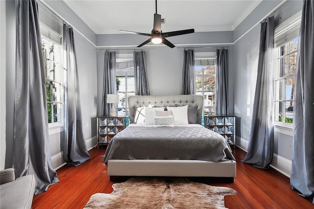 bedroom with multiple windows, ceiling fan, and hardwood / wood-style floors