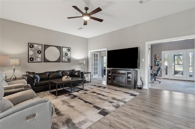 living room with french doors, light wood-type flooring, and ceiling fan