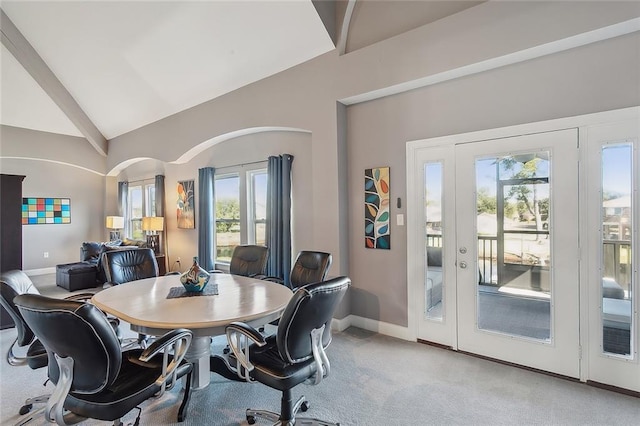 dining room with light colored carpet and vaulted ceiling