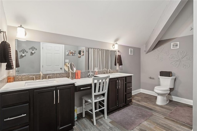 bathroom with beamed ceiling, hardwood / wood-style floors, vanity, and toilet