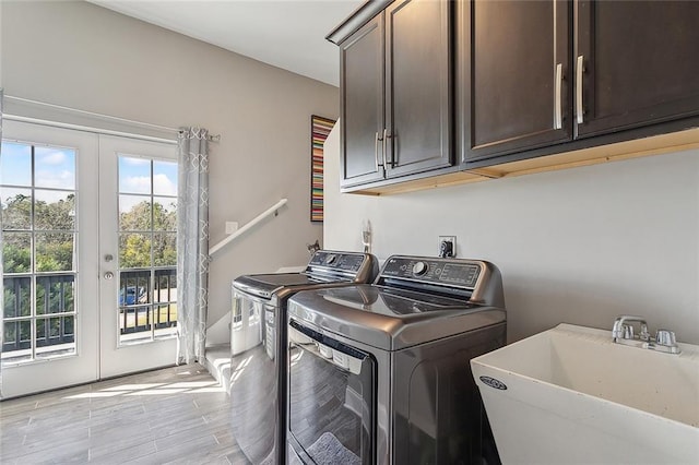 washroom featuring separate washer and dryer, sink, cabinets, and french doors