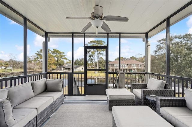 sunroom / solarium featuring ceiling fan, a water view, and a healthy amount of sunlight