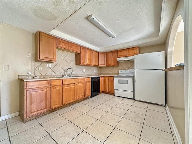 kitchen featuring a raised ceiling, sink, light tile patterned floors, and white appliances