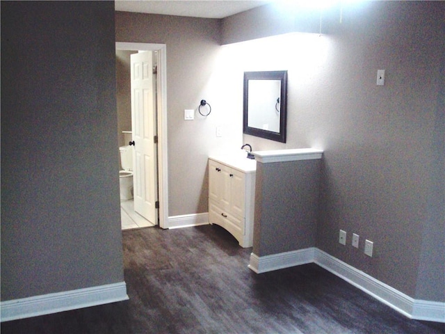 bathroom with wood-type flooring, vanity, and toilet