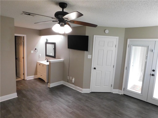 unfurnished bedroom with sink, dark wood-type flooring, a textured ceiling, and ceiling fan