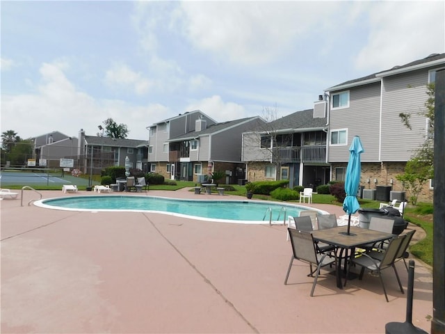 view of pool featuring tennis court and a patio area