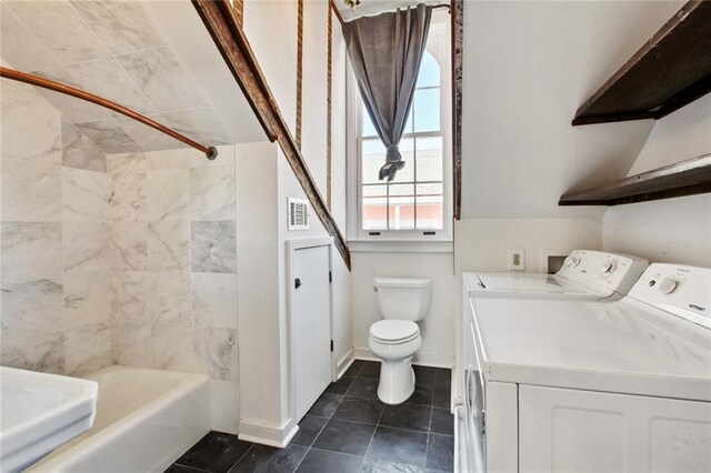 full bathroom featuring washing machine and clothes dryer, vanity, tiled shower / bath combo, and toilet