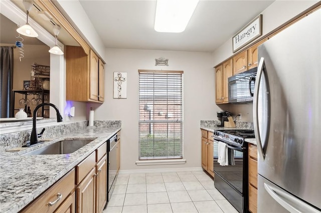 kitchen with sink, light stone counters, pendant lighting, light tile patterned floors, and black appliances