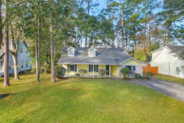 cape cod-style house with driveway, a front lawn, and fence