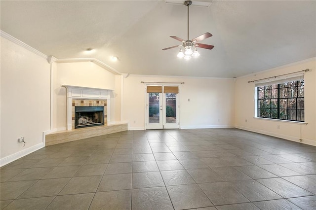 unfurnished living room with a tiled fireplace, ornamental molding, vaulted ceiling, and ceiling fan