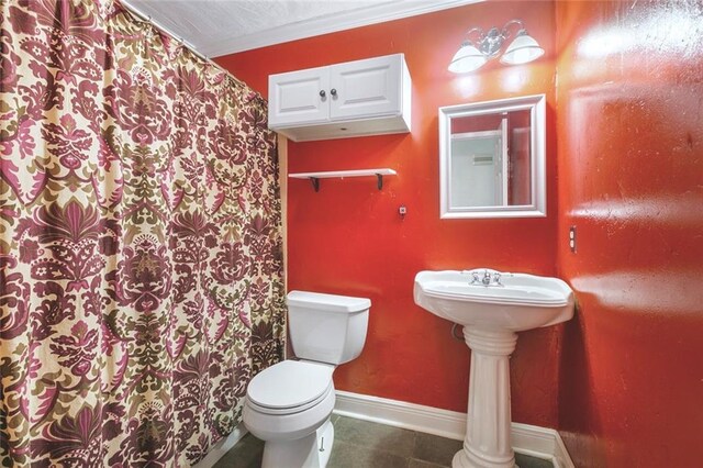 bathroom featuring crown molding and toilet