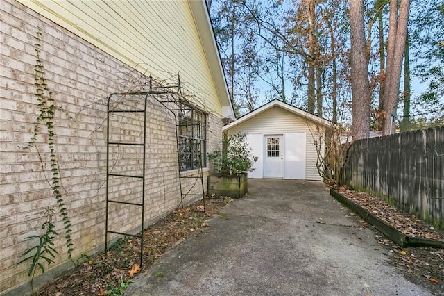 view of side of home featuring an outdoor structure and fence