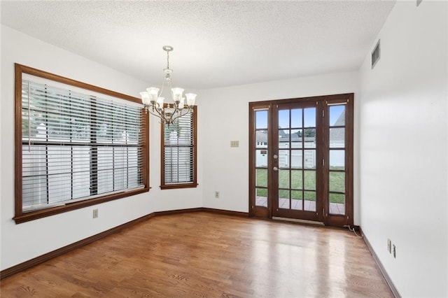 5512 David Dr, Kenner, LA 70065 - unfurnished room with a chandelier, wood finished floors, a water view, and a textured ceiling