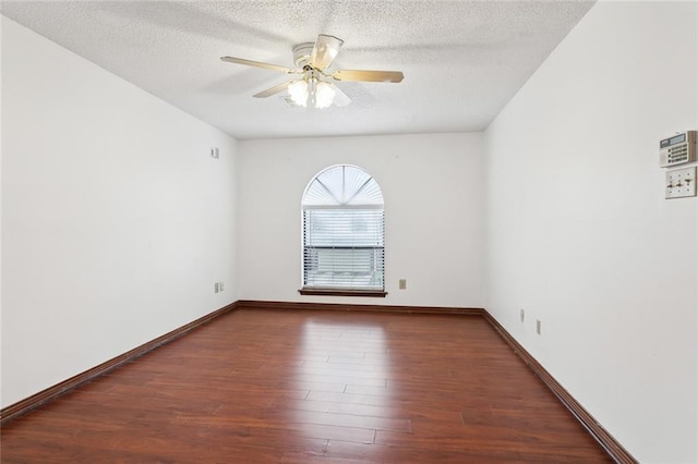 empty room featuring a textured ceiling, dark hardwood / wood-style floors, and ceiling fan