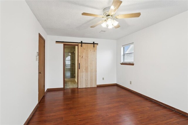 5512 David Dr, Kenner, LA 70065 - unfurnished bedroom featuring wood finished floors, a barn door, a textured ceiling, and ceiling fan