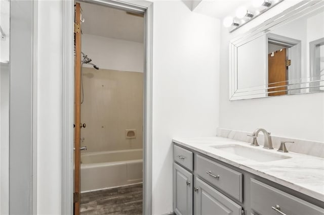 bathroom with bathing tub / shower combination, hardwood / wood-style floors, and vanity