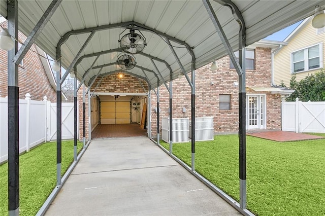 view of car parking featuring a carport, ceiling fan, and a yard