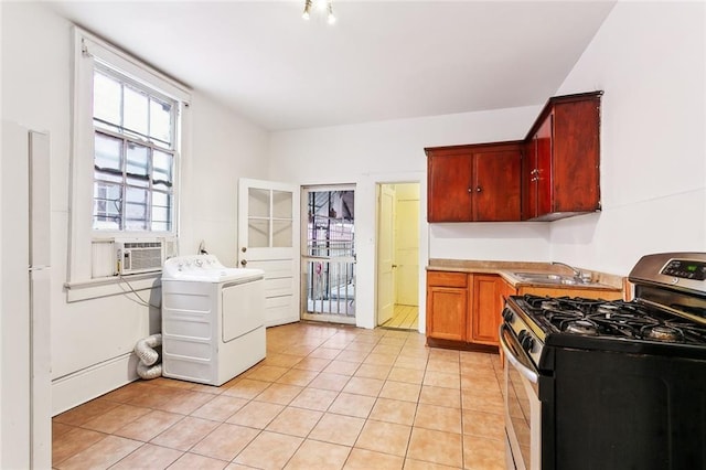 kitchen with sink, stainless steel range with gas cooktop, cooling unit, washer / dryer, and light tile patterned floors