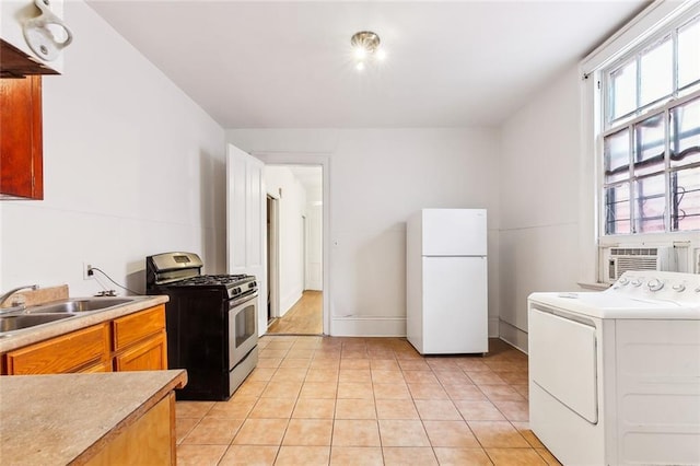 kitchen featuring stainless steel gas range, white fridge, cooling unit, washer / dryer, and light tile patterned floors