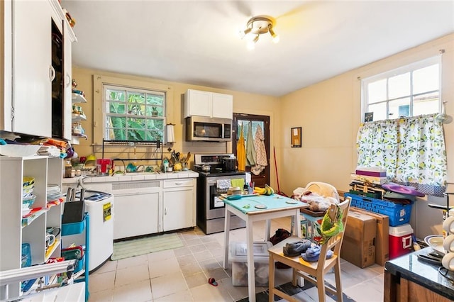 kitchen featuring white cabinets, light tile patterned floors, and stainless steel appliances