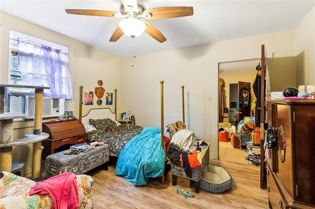 bedroom featuring ceiling fan, cooling unit, and light hardwood / wood-style flooring