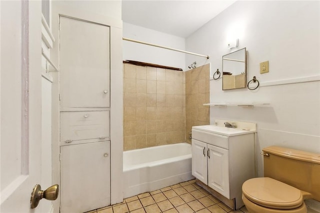 full bathroom featuring tile patterned flooring, vanity, toilet, and tiled shower / bath