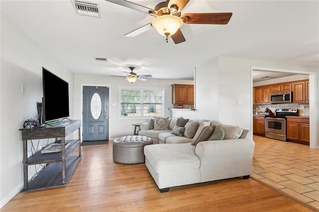 living room with ceiling fan and light wood-type flooring