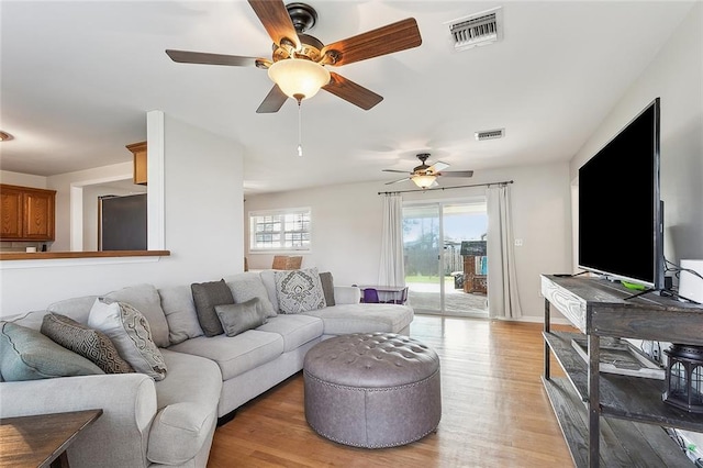 living room featuring ceiling fan and light hardwood / wood-style flooring